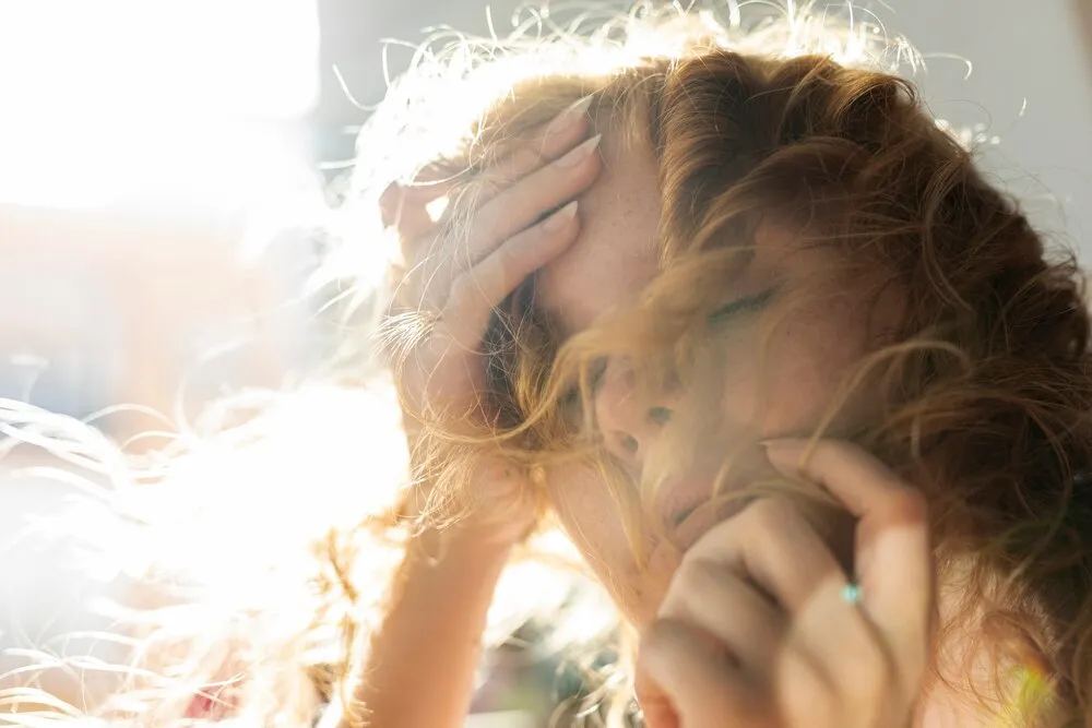 primer plano de una mujer cubriéndose la cara con el pelo
