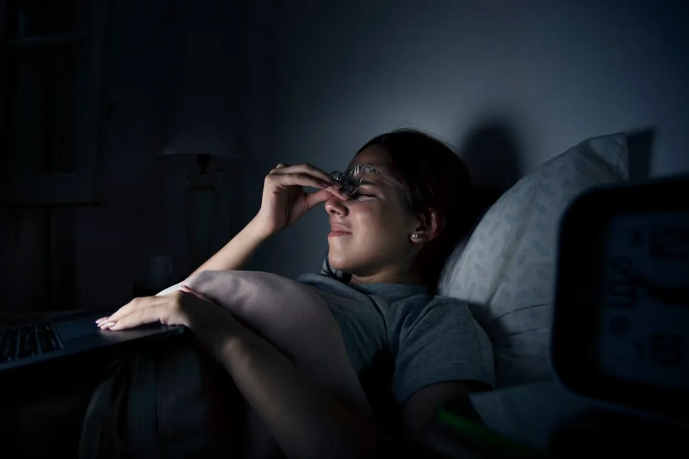 Mujer agotada trabajando hasta tarde en casa