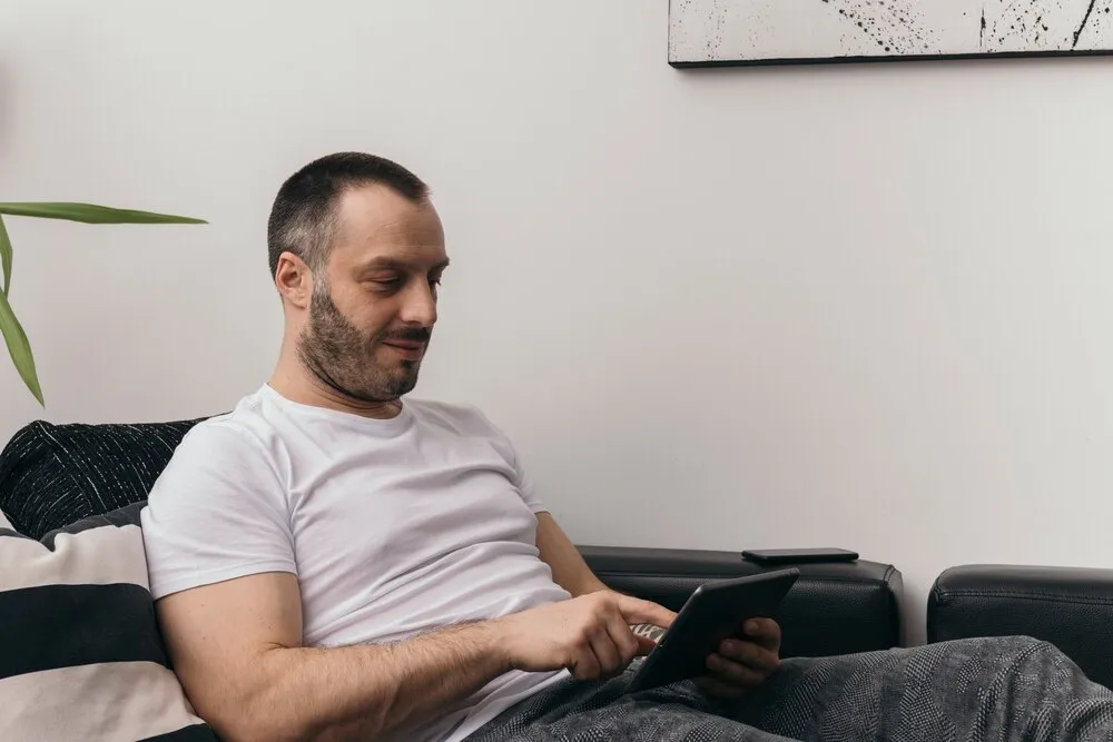 hombre usando una tablet en el sofá