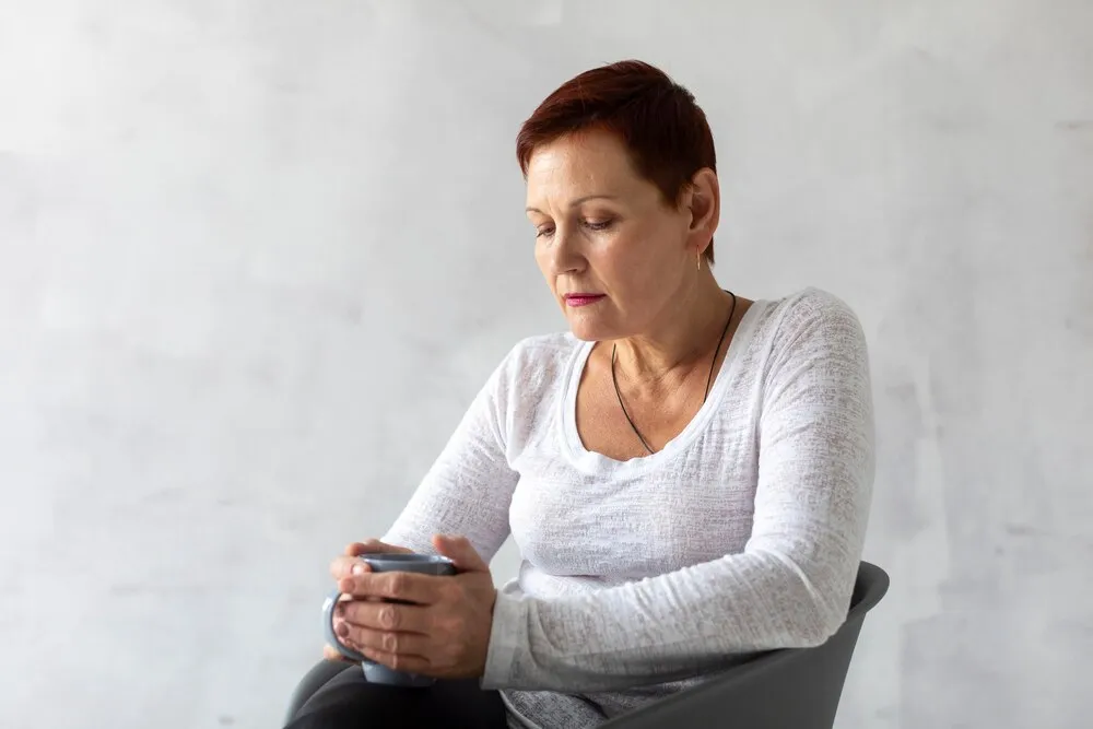mujer madura sosteniendo una taza azul