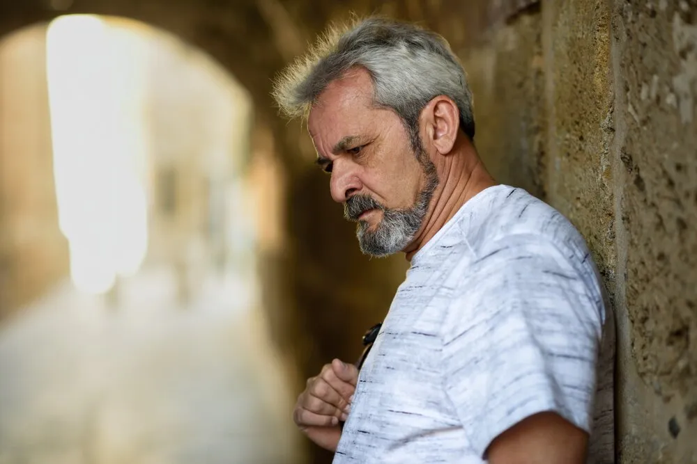 Retrato de un hombre maduro y serio con fondo urbano.