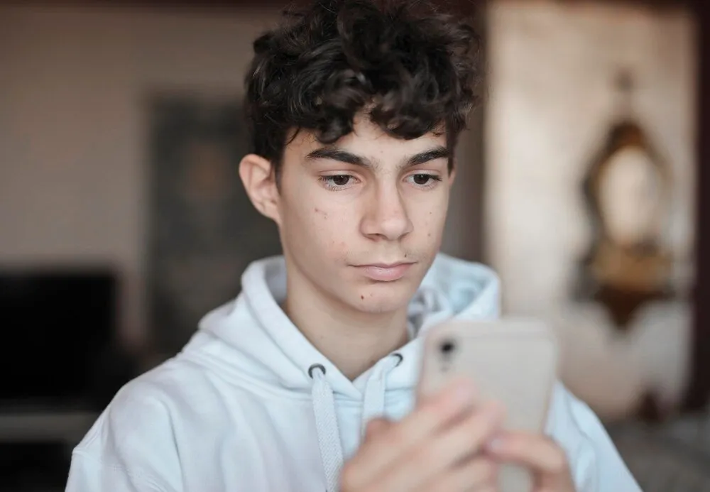 un chico joven usa un smartphone