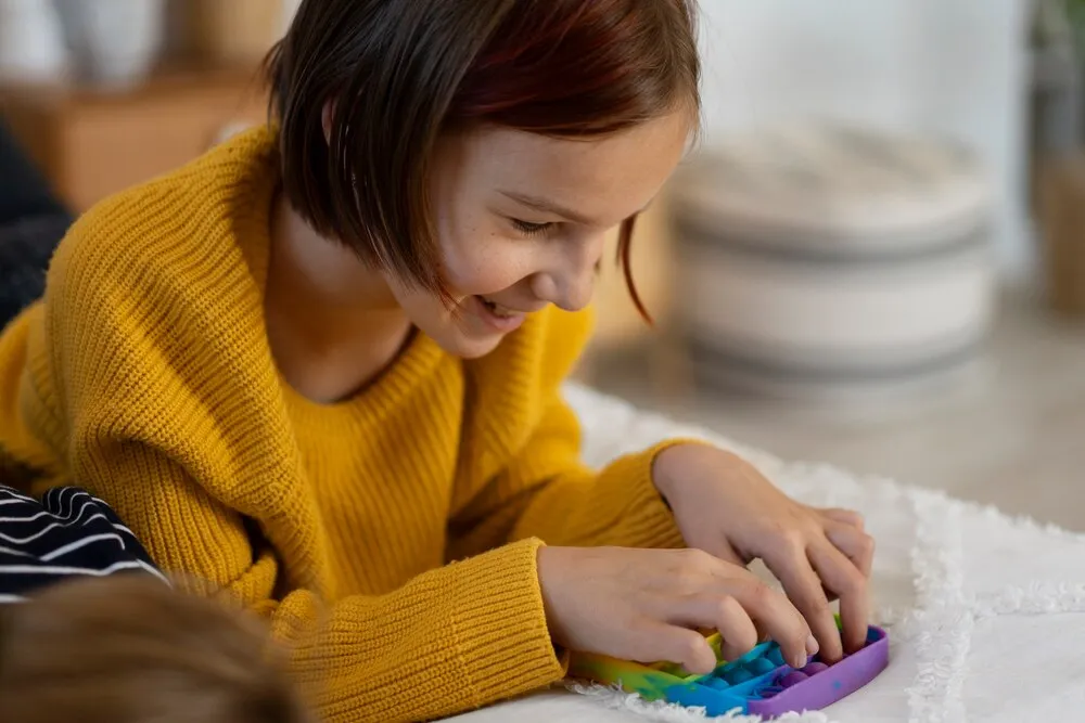 primer plano de un niño jugando con un juguete pop it