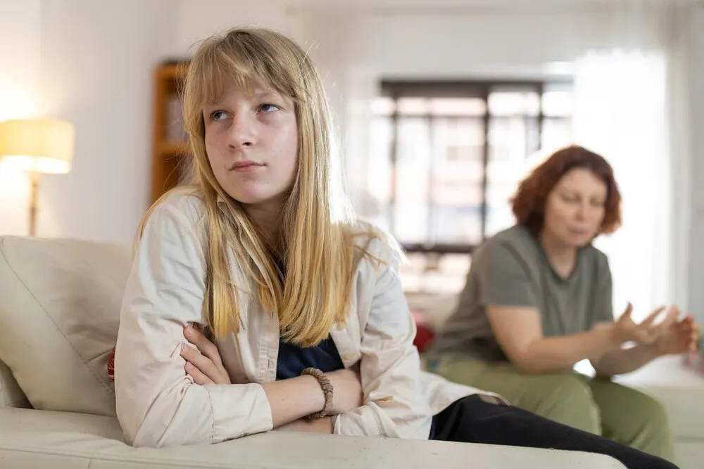 chica adolescente molesta ignorando a su madre durante una discusión en casa