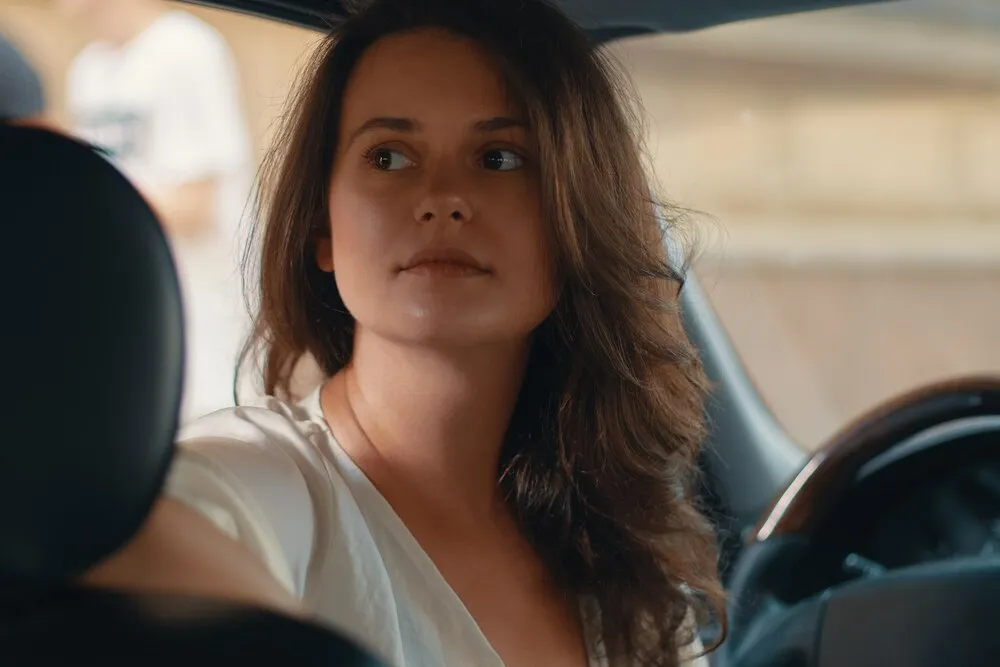 retrato en primer plano de una mujer con la mano en el volante
