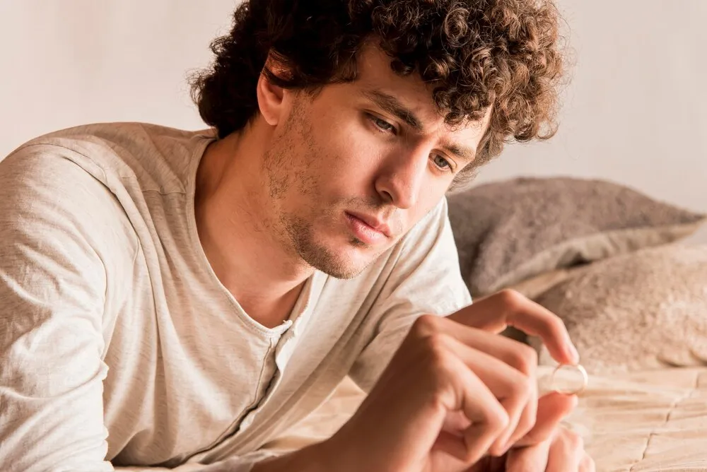 primer plano de un hombre mirando un anillo de bodas