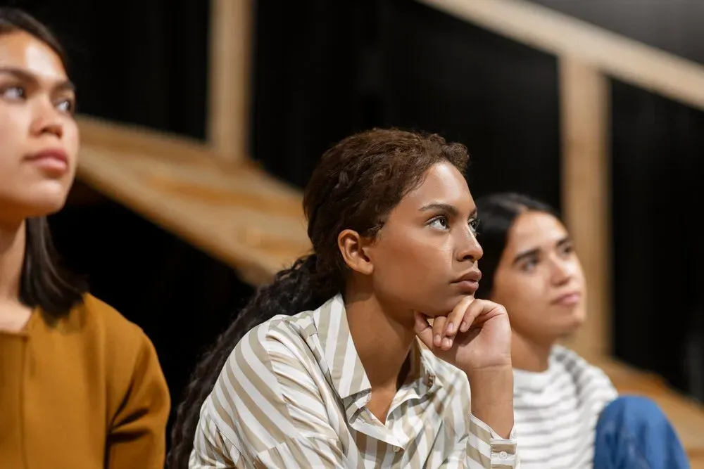 mujeres prestando atención teatro