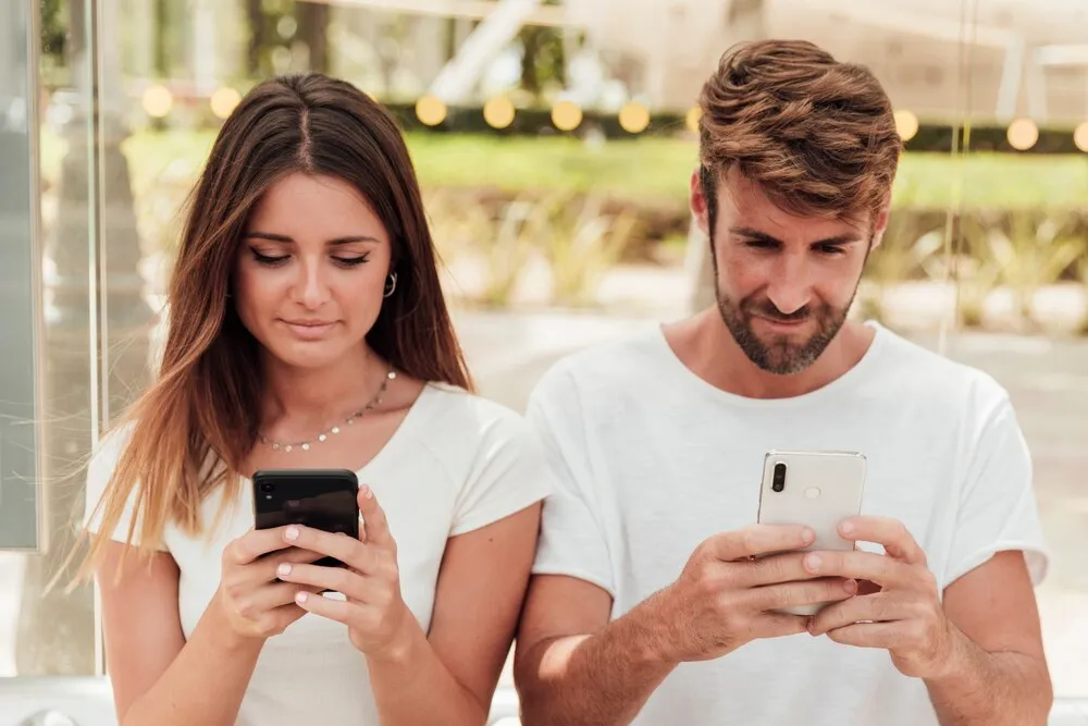 hombre y mujer con smartphones enviando mensajes de texto