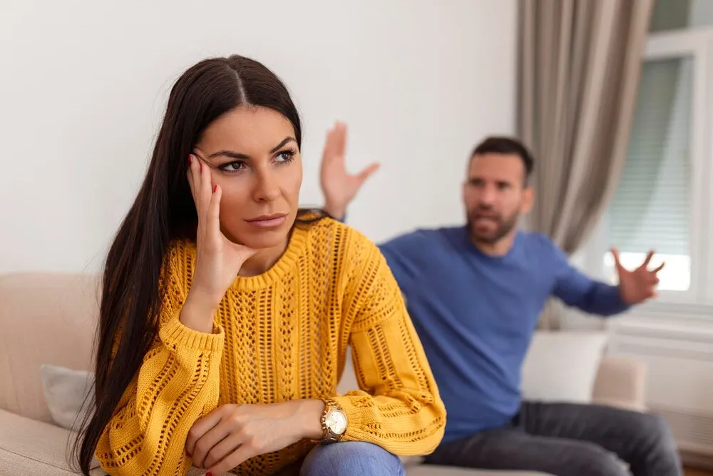 pareja joven teniendo una discusión conflicto malas relaciones enfado furia mujer enfadada pareja joven sentada en el sofá del salón teniendo una pelea familiar o riña sufriendo por un malentendido